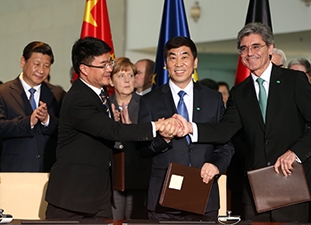 Siemens CEO Joe Kaeser (R) shakes hands with Huang Dinan (L), Vice-Chairman of Shanghai Electric and Cao Peixi (M), Chairman of Huaneng Power
