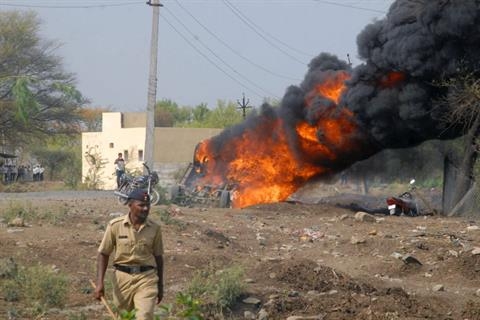 A vehicle burns after crowds rioted in response to power cuts