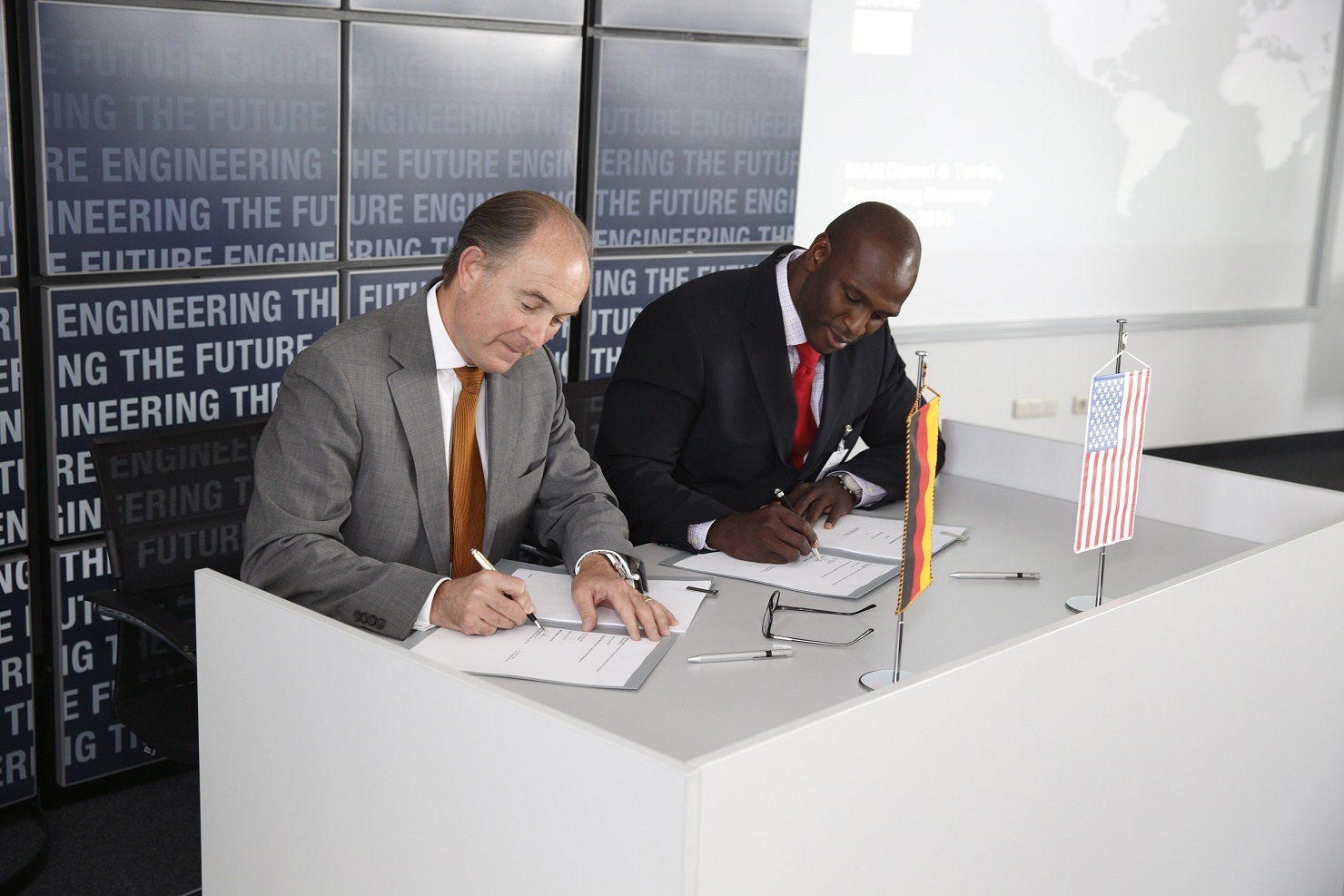 M. Riley and H. Barnes sign the deal in Augsburg