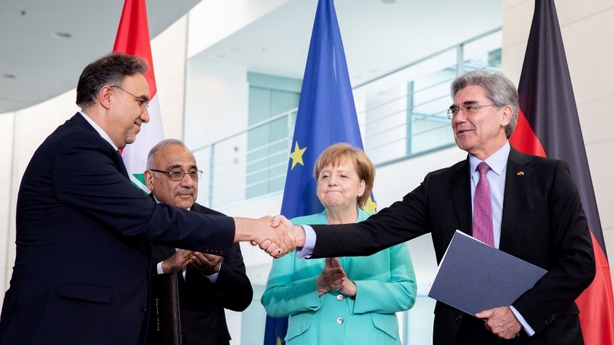 Iraq's Energy Minister Luay Al-Khateeb shaking hands with Siemens CEO Joe Kaeser