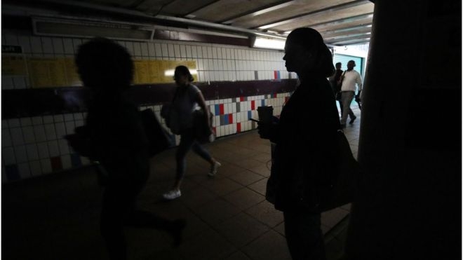People walk in the darkness in the London tube